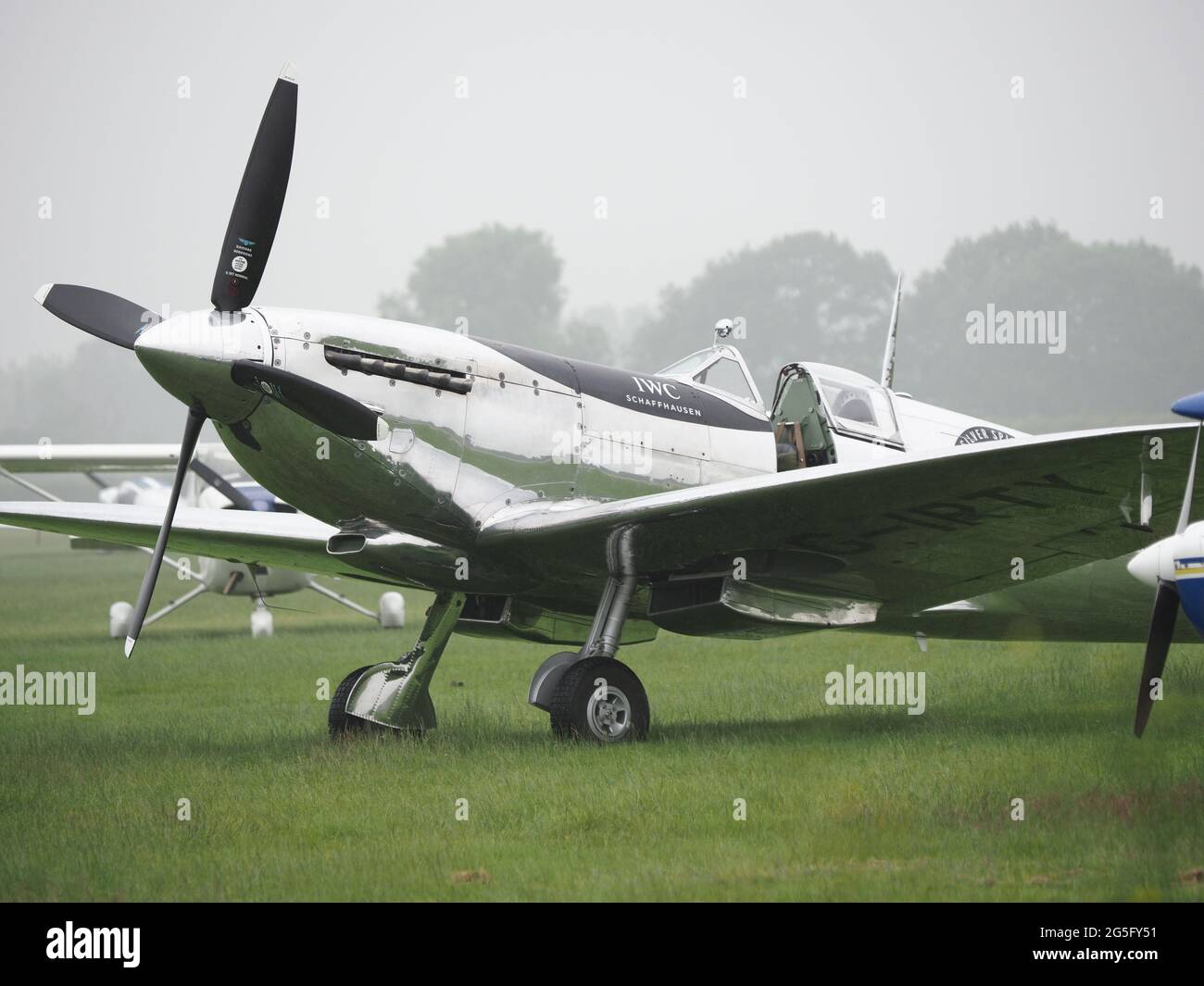 Headcorn, Kent, Regno Unito. 27 giugno 2021. Battle of Britain Aero Legends Air Show: Pioggia e maltempo hanno acquistato un primo fine a questo spettacolo aereo con il momento culminante del giorno le frecce rosse annullato. Un volo con un record di 9 Spitfires è stato anche annullato, con loro costretti a sfilare lentamente lungo la pista prima di essere parcheggiato da un lato. Nella foto: Uno speciale Silver Mark IX Spitfire (Girty) costruito nel 1943 (un team circumnavigato il mondo in questo aereo nel 2019) è manovrato a mano alla fine del salone aereo. Credit: James Bell/Alamy Live News Foto Stock