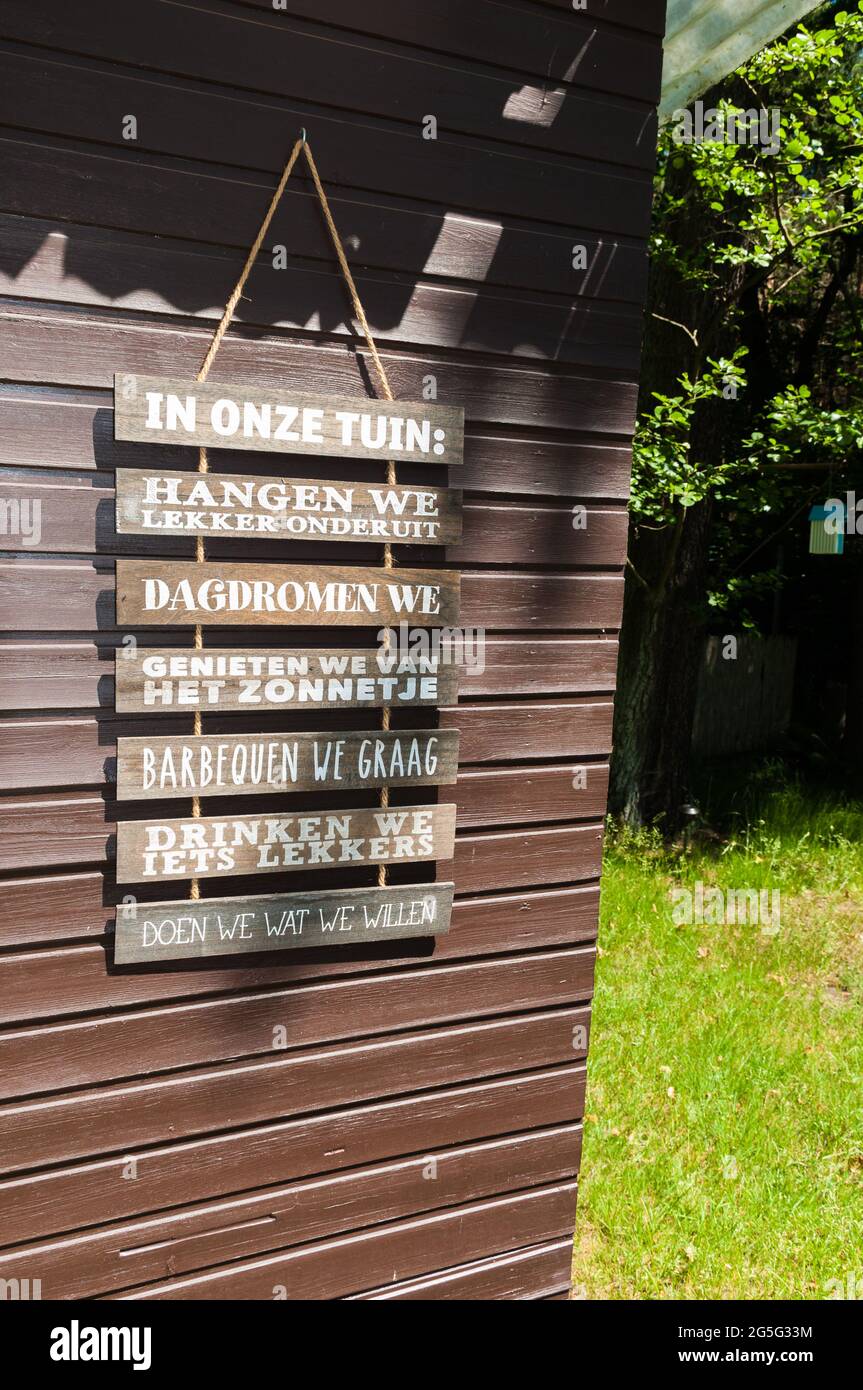 Decorazione su un capannone da giardino. Cartelli appesi in olandese. Istruzioni cosa fare in giardino. Foto Stock