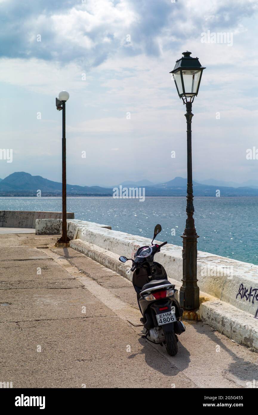 LOUTRAKI, GRECIA - AGOSTO 28 2018 : Scooter sul lungomare di Loutraki, Peloponneso sullo sfondo. Foto Stock