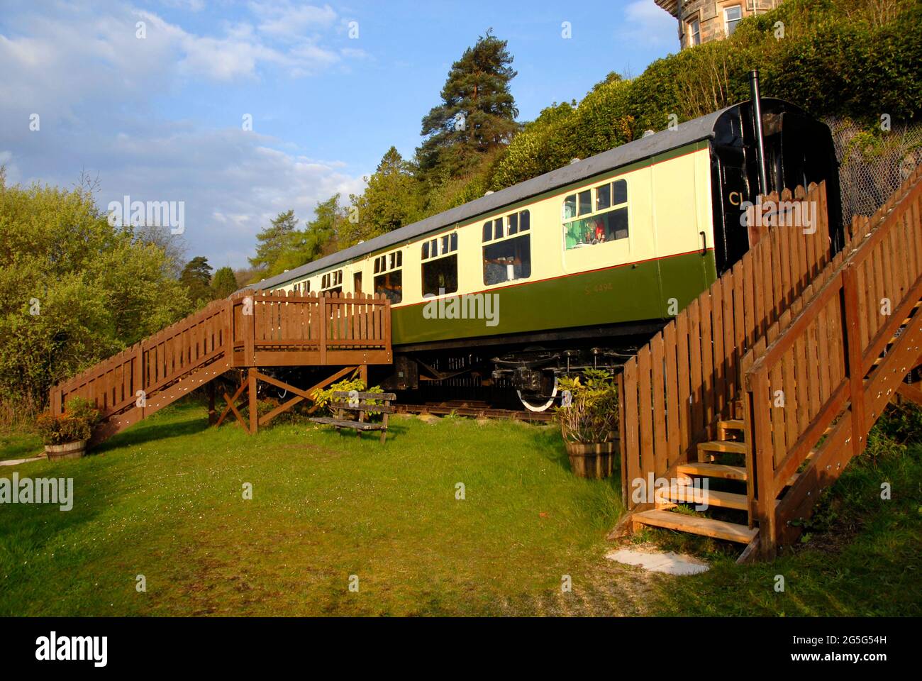 Vecchi autobus ferroviari accanto alla linea ferroviaria, Loch AWe, Scozia convertito in attraente alloggio self-catering per vacanze Foto Stock