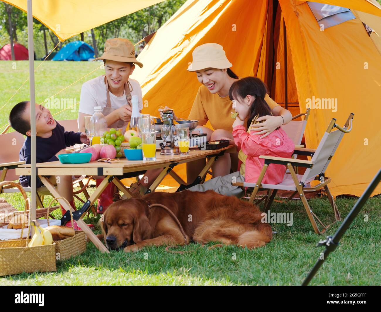 Famiglia felice di quattro e cane animale domestico hanno un picnic all'aperto foto di alta qualità Foto Stock
