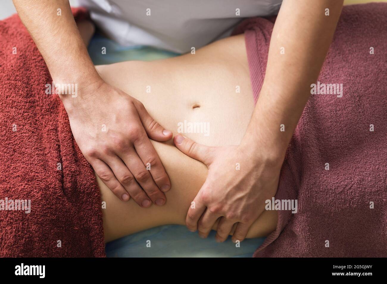 Il chiropractor esegue un massaggio sull'addome. Foto Stock