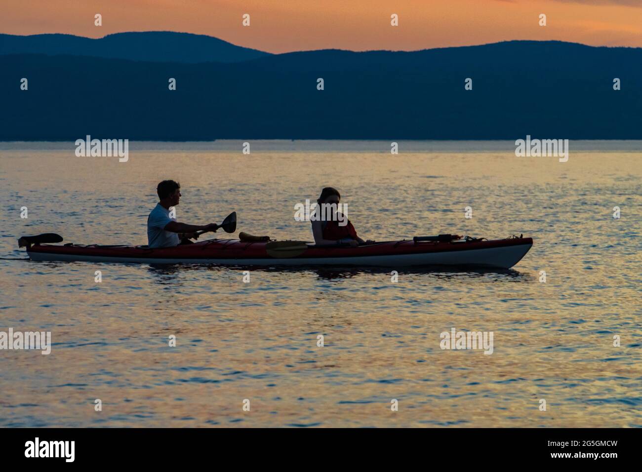 Coppia che ama il kayak in tandem sul lago Champlain al tramonto Foto Stock
