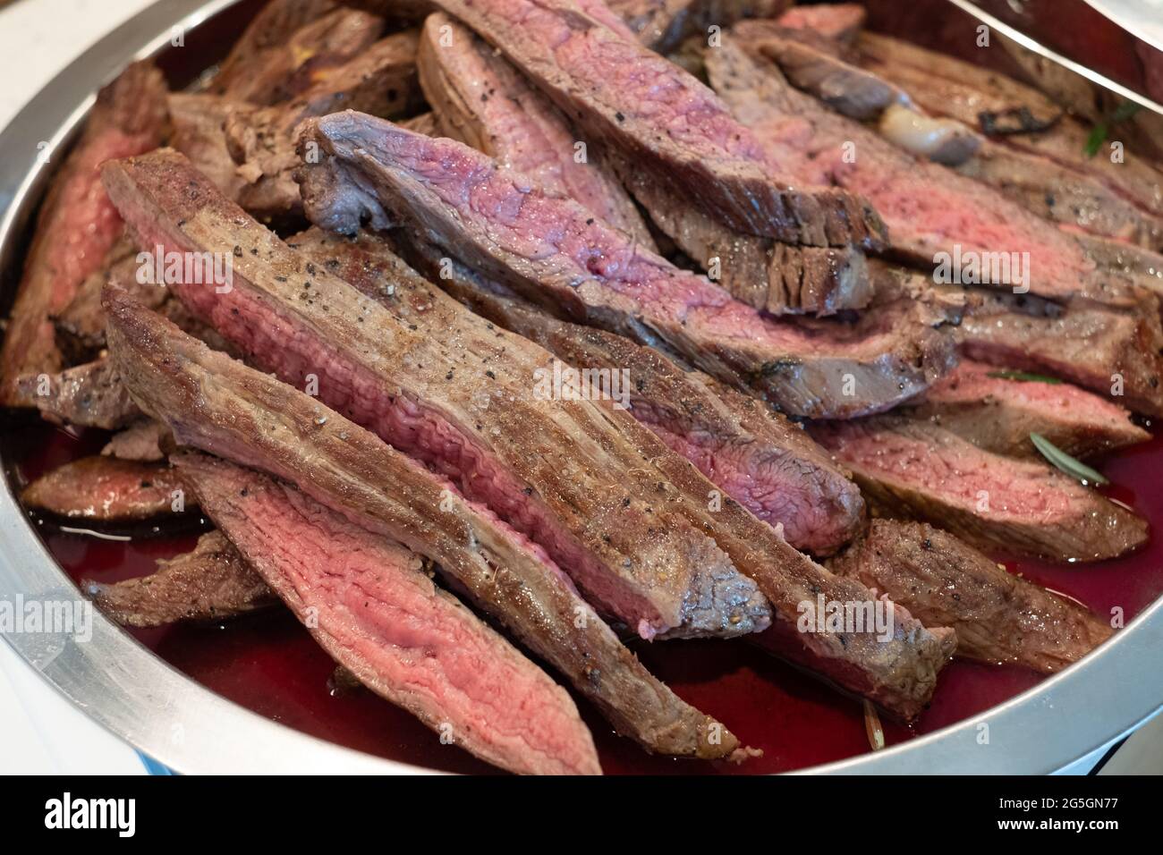 Carne rossa sanguinosa servita su un vassoio cottura di carne. Foto Stock