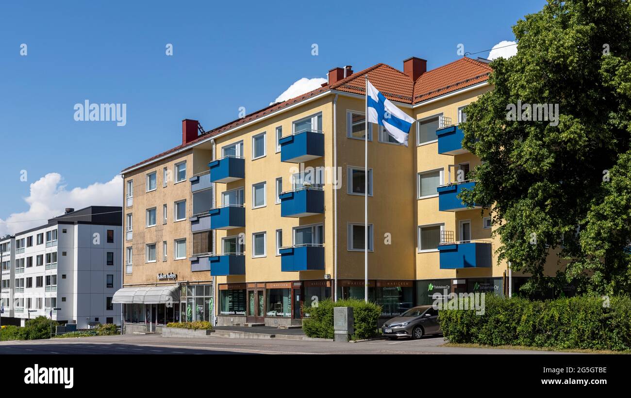 Bandiera finlandese che sorvola l'edificio residenziale di Helsinki Foto Stock