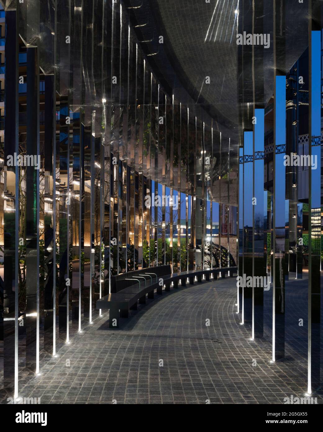 Vista attraverso la struttura a passerella specchiata al crepuscolo. Gasholder Park, Londra, Regno Unito. Architetto: Bell Phillips Architects, 2021. Foto Stock
