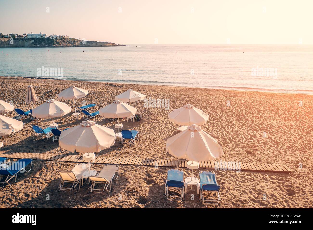 Sedie da spiaggia vuote con ombrelloni, spiaggia sabbiosa costa senza persone in estate giorno. Foto Stock