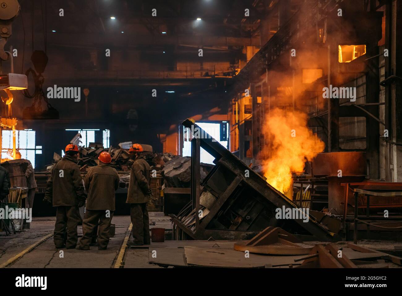 Produzione di acciaio presso impianti metallurgici, laboratori con operai irriconoscibili e altoforno sotterraneo. Foto Stock