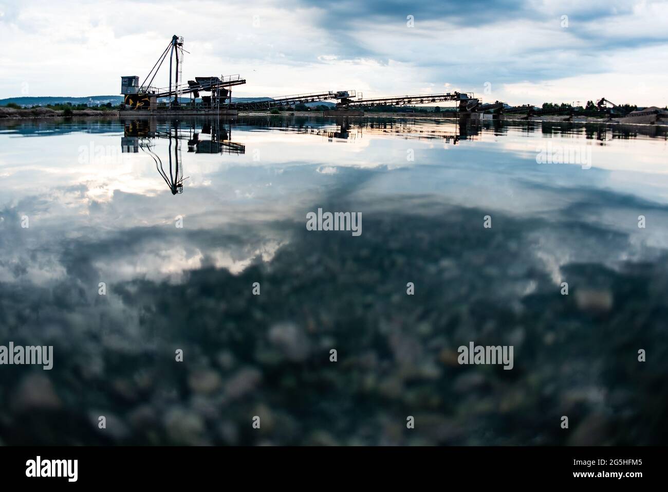 Rosdorf, Germania. 28 Giugno 2021. Le nuvole si riflettono nelle prime ore del mattino nello stagno della cava di Rosdorf. Credit: Swen Pförtner/dpa/Alamy Live News Foto Stock