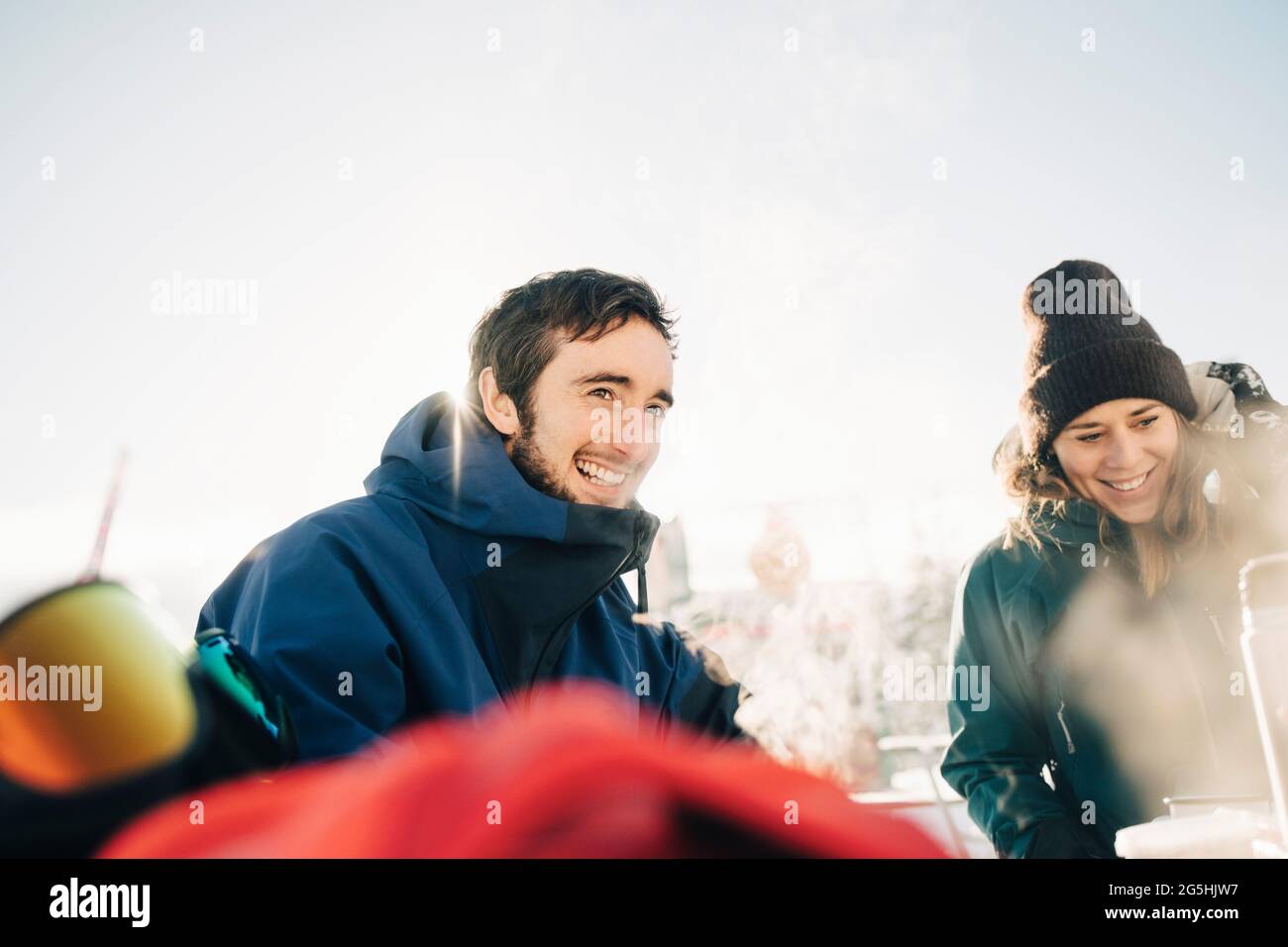 Sorridendo amici maschili e femminili che si divertono nella stazione sciistica Foto Stock
