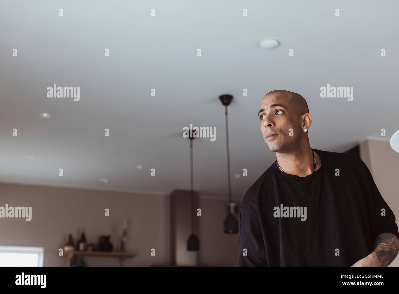 Uomo ispanico che contempla mentre si guarda via a casa Foto Stock
