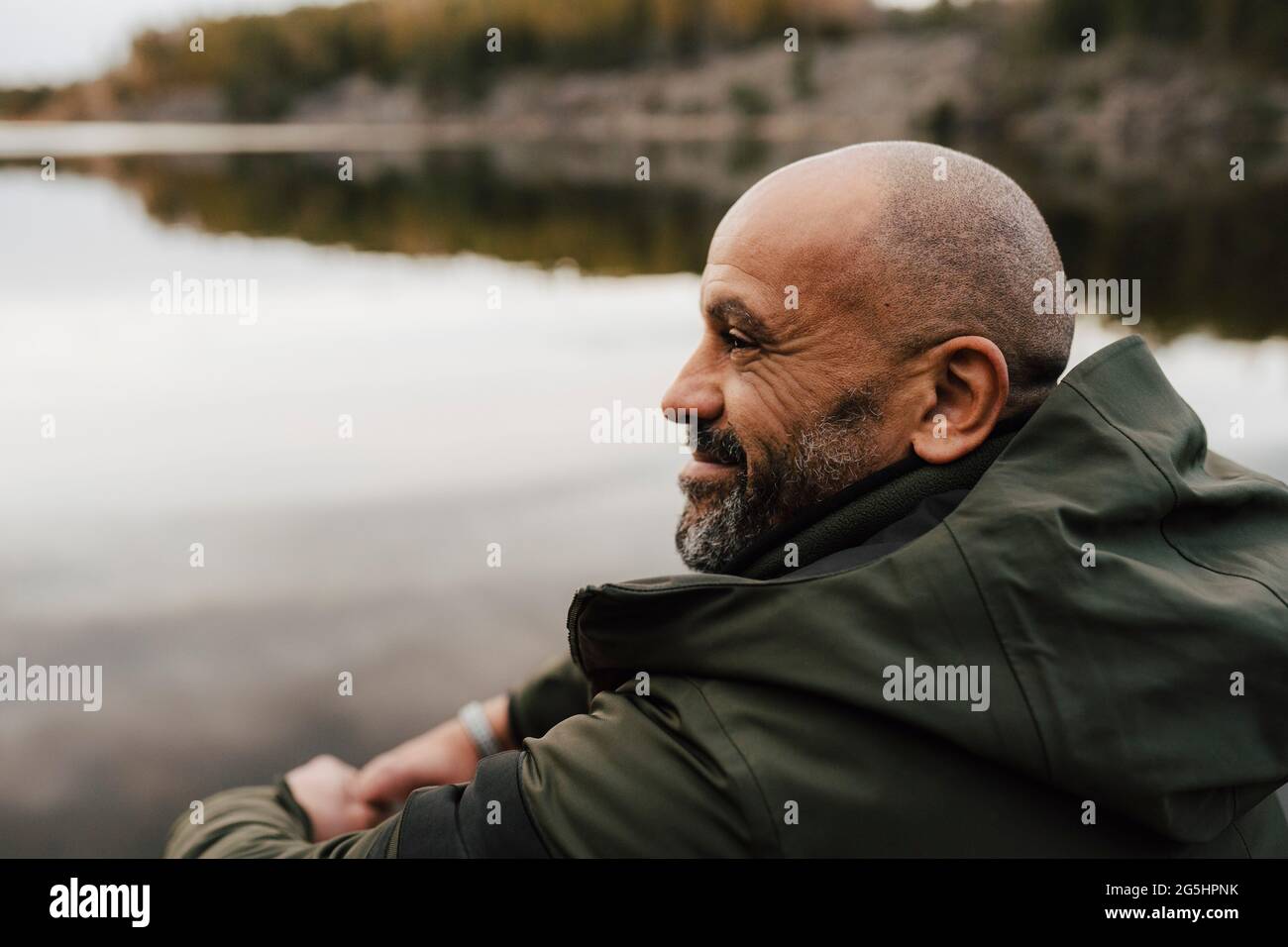 Sorridente escursionista maschile guardando via dal lago durante la vacanza Foto Stock