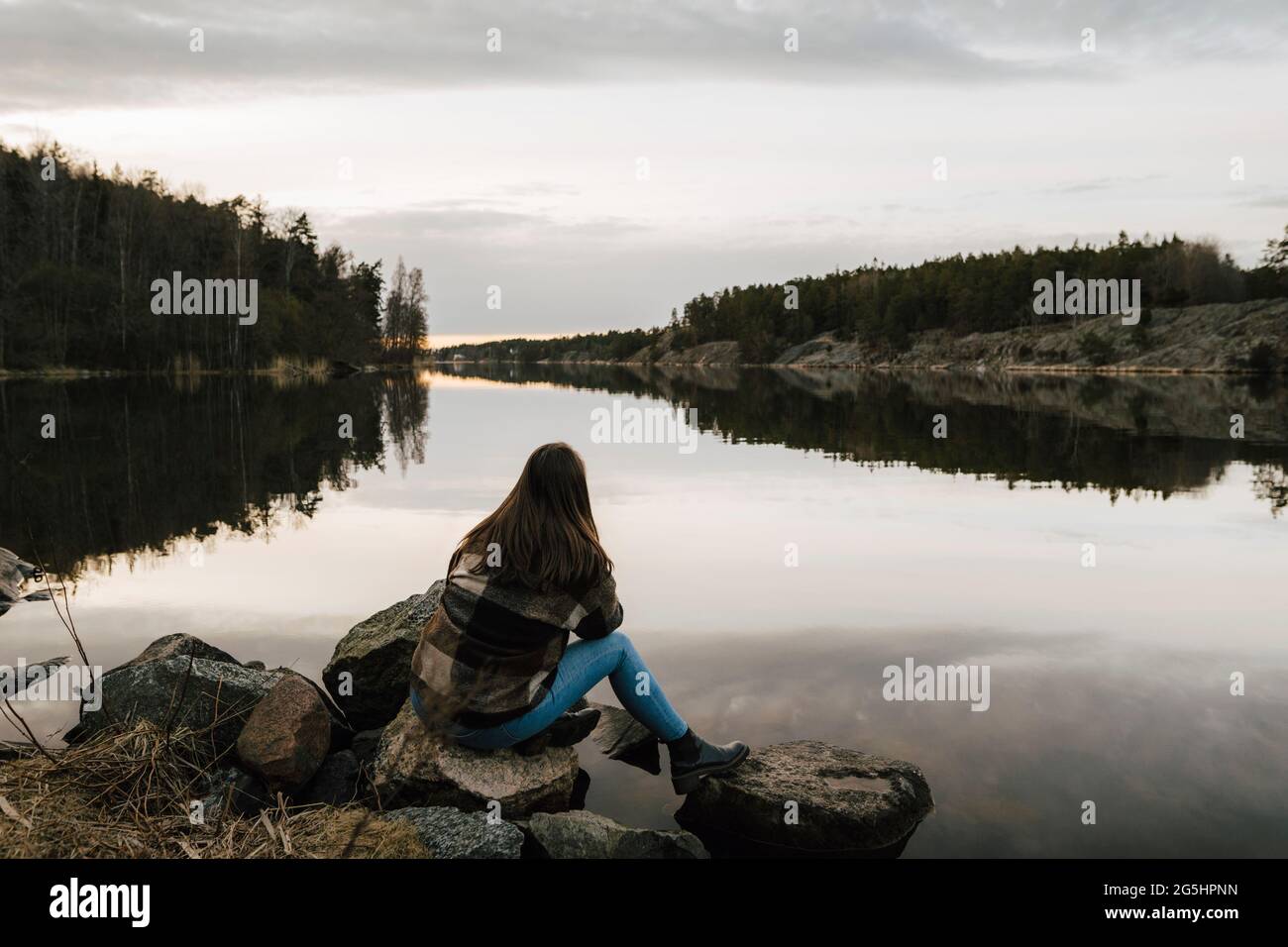Vista posteriore della giovane escursionista che ammira il lago durante la vacanza Foto Stock