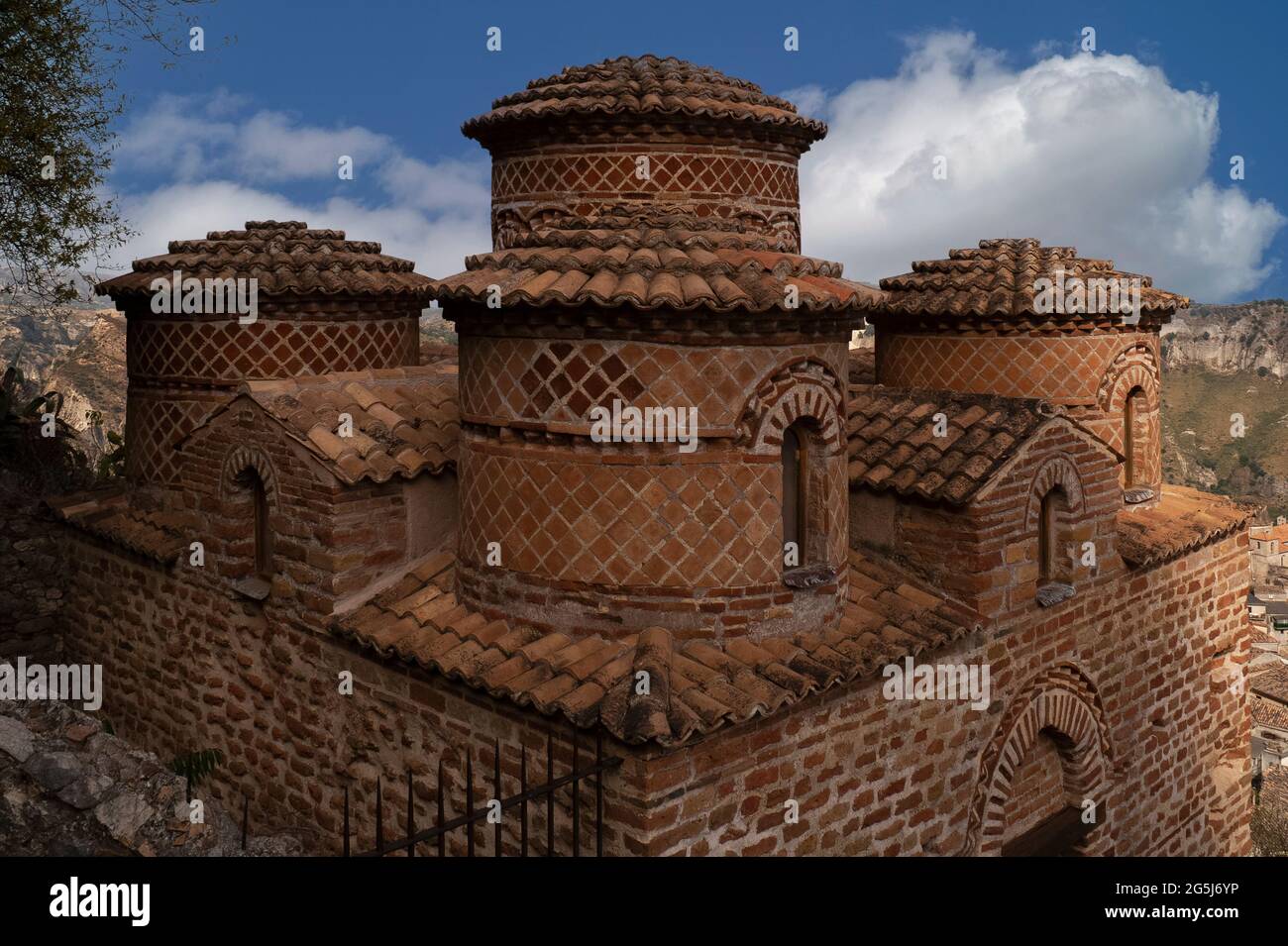 La Cattolica di stilo, chiesa monastica bizantina sopra stilo in Calabria. Le pianelle in terracotta con motivi decorativi diagonali sono fodere cinque torri a tamburo sormontate da cupole poco profonde o cupole che si innalzano attraverso un tetto a pantera. ‘La Cattolica’ fu costruita nel 800s d.C. dai monaci trogloditi basiliani a pianta quadrata a croce greca. Ha una semplice facciata in mattoni, tre absidi orientali e quattro colonne centrali riutilizzate dell'antica colonia greca costiera di Kaulonia o Kaulon, distrutta da Roma nel 200 a.C. Foto Stock