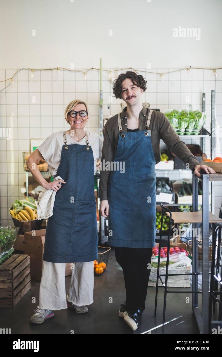 Imprenditore maschile in piedi da dipendente femminile in negozio Foto Stock