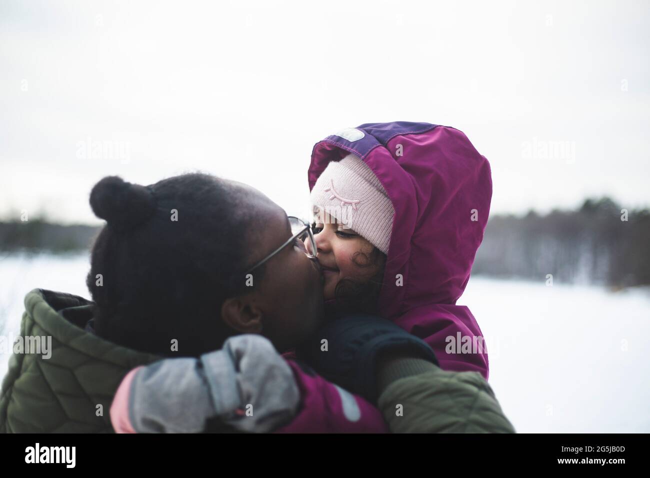 Madre affettuosa che bacia la figlia in bocca Foto Stock
