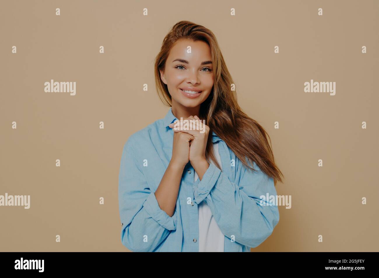 Affascinante giovane donna europea sorridente che posa in camera in studio Foto Stock