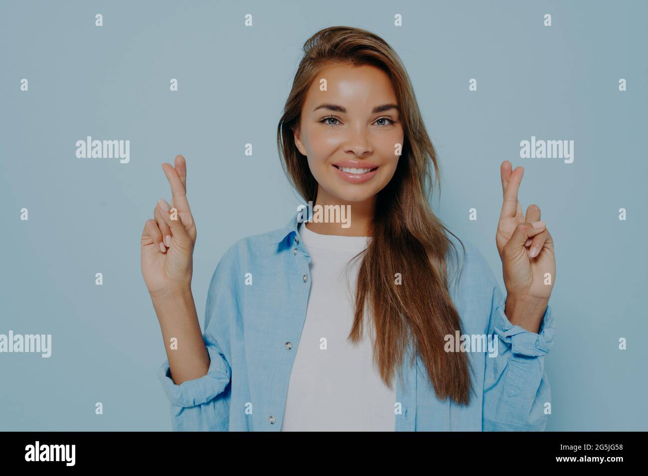 Donna gioiosa in abiti casual punta le dita trasversali Foto Stock