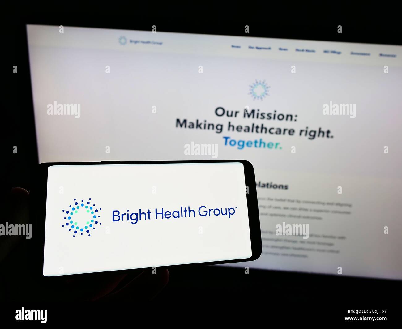 Persona che tiene il cellulare con il logo della società di assicurazione statunitense Bright Health Group Inc. Sullo schermo di fronte alla pagina web aziendale. Mettere a fuoco il display del telefono. Foto Stock