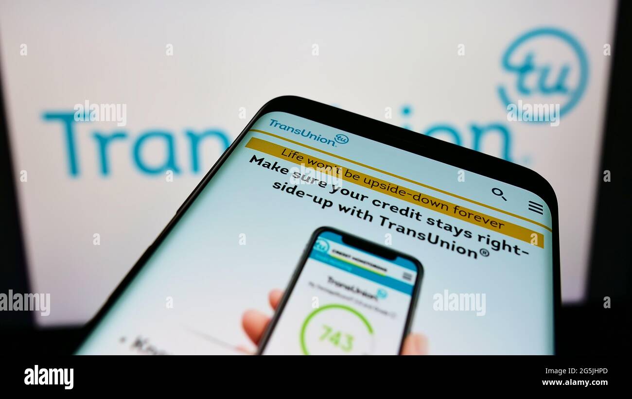 Smartphone con il sito Web aziendale dell'agenzia di reporting del credito statunitense TransUnion sullo schermo davanti al logo dell'azienda. Mettere a fuoco in alto a sinistra del display del telefono. Foto Stock