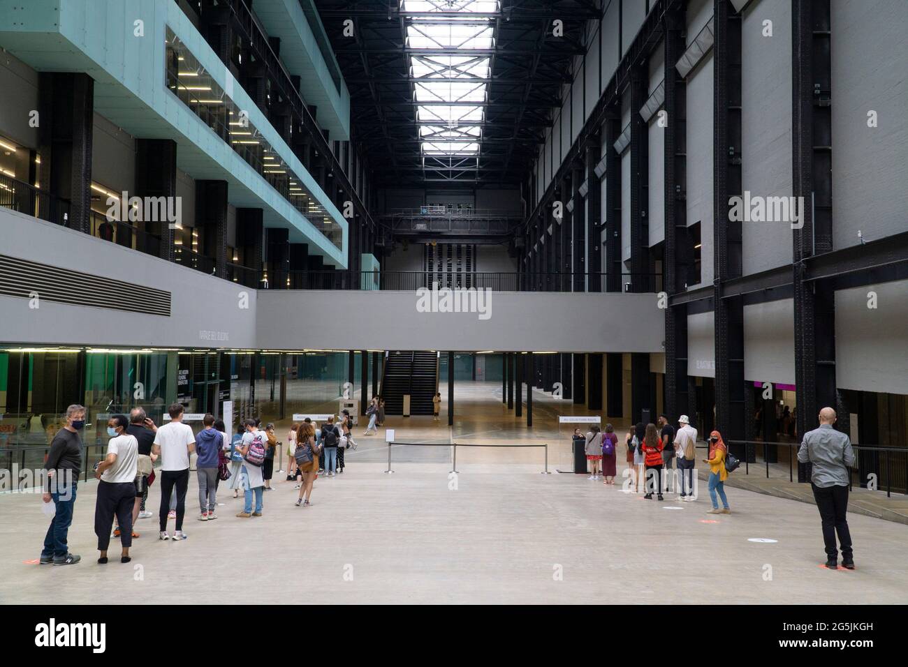 Londra, UK, 26 giugno 2021: Nella turbine Hall di Tate si formano delle code socialmente distanziate moderne dovute a protocolli di sicurezza covid. Come tutti i musei e le gallerie d'arte dall'inizio della pandemia del coronavirus, stanno operando una capacità molto ridotta e persino le esposizioni libere devono essere pre-prenotate. Anna Watson/Alamy Foto Stock