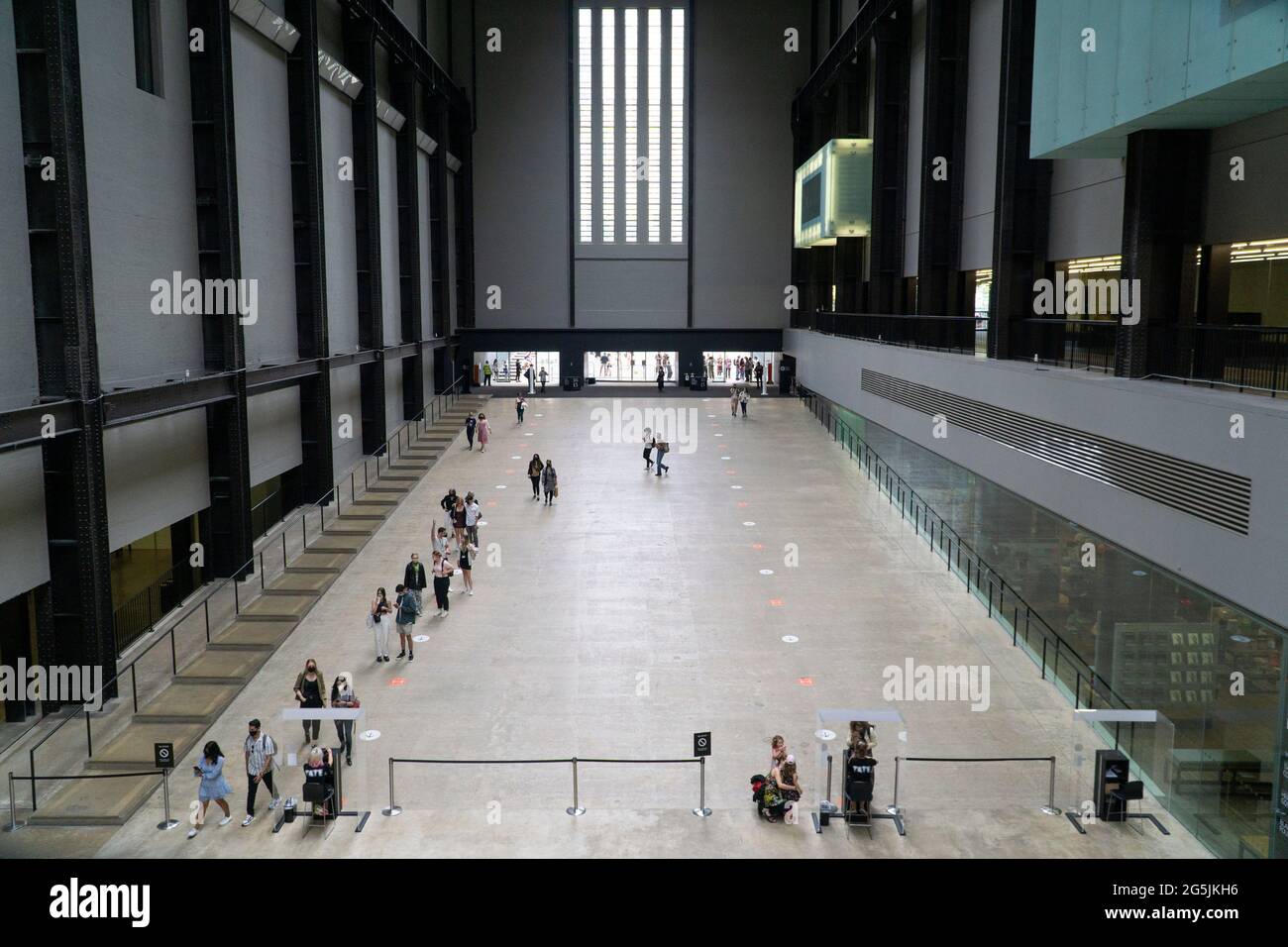 Londra, UK, 26 giugno 2021: Nella turbine Hall di Tate si formano delle code socialmente distanziate moderne dovute a protocolli di sicurezza covid. Come tutti i musei e le gallerie d'arte dall'inizio della pandemia del coronavirus, stanno operando una capacità molto ridotta e persino le esposizioni libere devono essere pre-prenotate. Anna Watson/Alamy Foto Stock