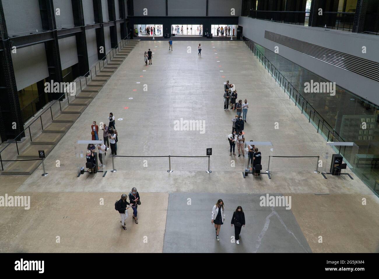 Londra, UK, 26 giugno 2021: Nella turbine Hall di Tate si formano delle code socialmente distanziate moderne dovute a protocolli di sicurezza covid. Come tutti i musei e le gallerie d'arte dall'inizio della pandemia del coronavirus, stanno operando una capacità molto ridotta e persino le esposizioni libere devono essere pre-prenotate. Anna Watson/Alamy Foto Stock