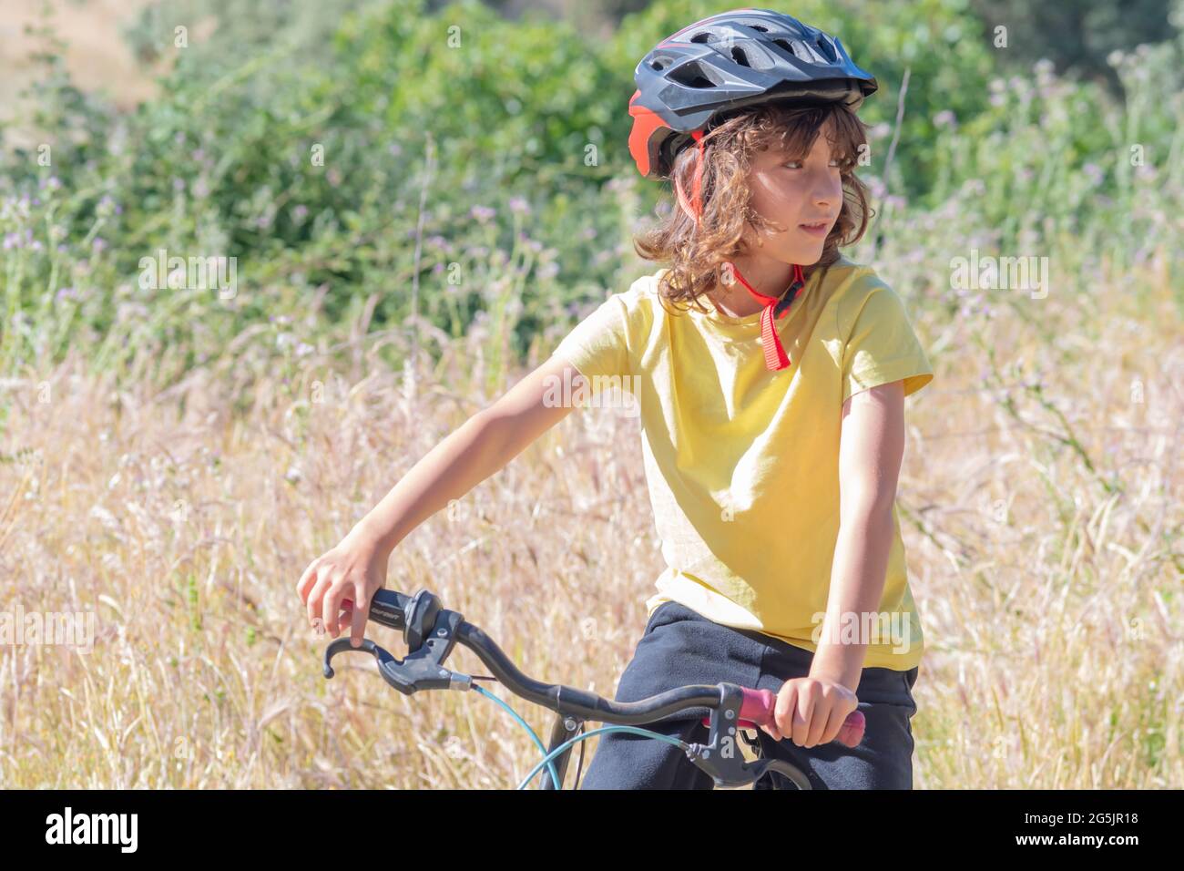 piccolo con casco di sicurezza ha divertimento e sorrisi mentre cavalca la sua moto. tempo libero e concetto di tempo libero Foto Stock