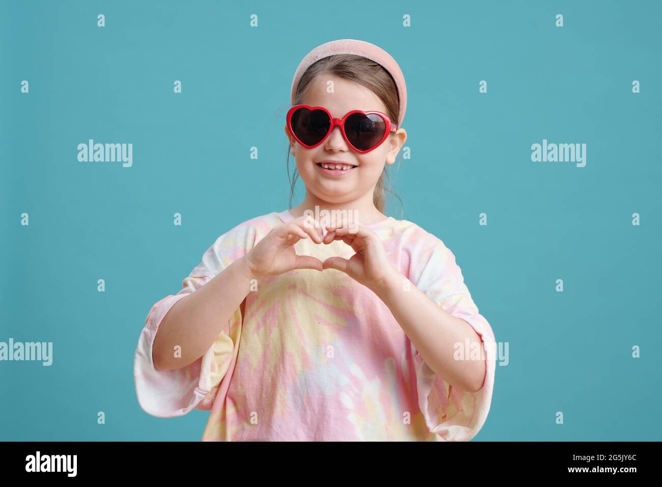 Felice ragazza elegante in occhiali da sole con lente a forma di cuore Foto Stock