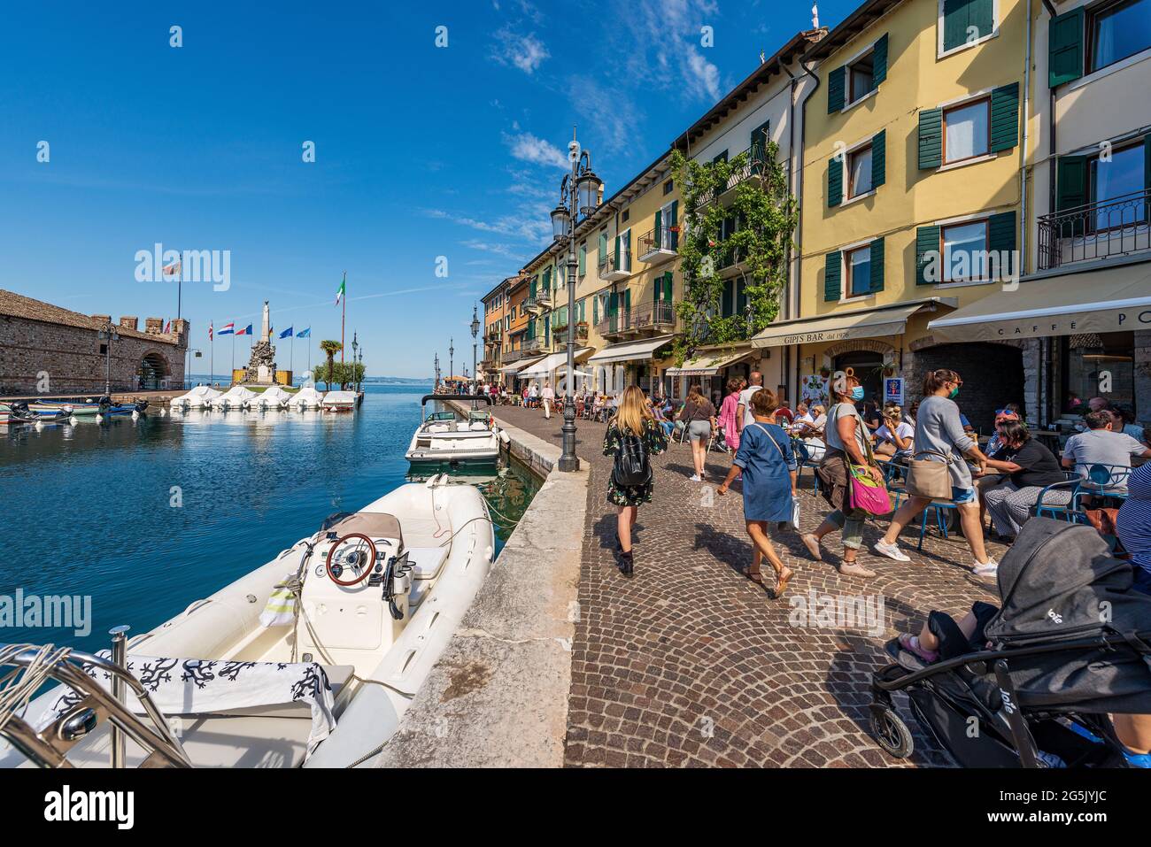 Piccolo porto del villaggio di Lazise con barche ormeggiate. Località turistica sulla costa del Lago di Garda. Verona, Veneto, Italia, Europa. Foto Stock