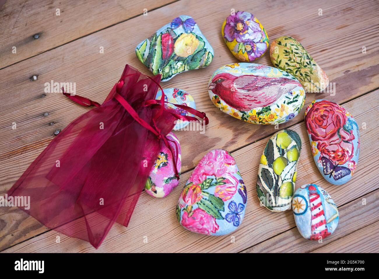 Sassi dipinti, pietre dipinti uccelli e fiori, decorazione. Su un tavolo di  legno Foto stock - Alamy