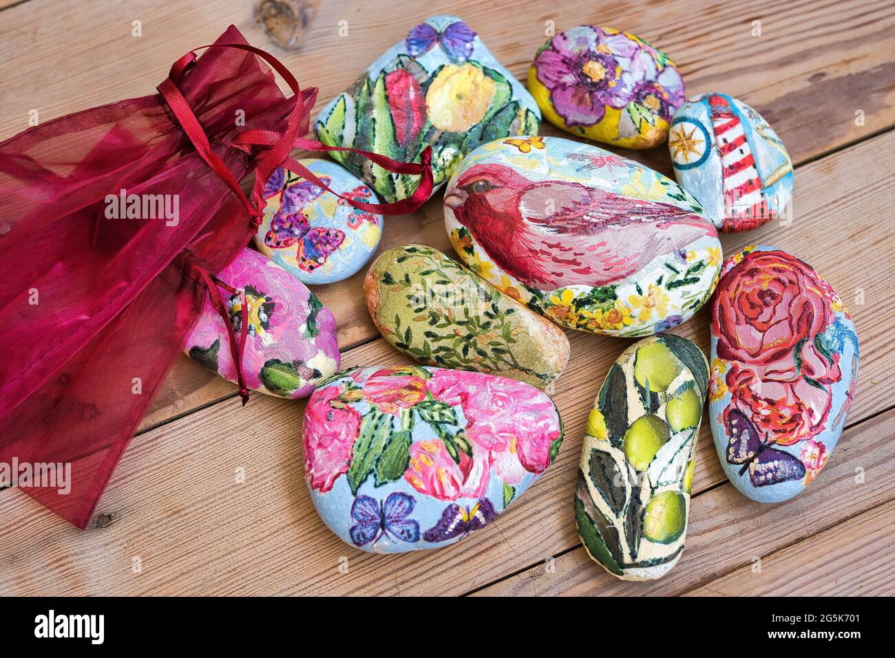 Sassi dipinti, pietre dipinti uccelli e fiori, decorazione. Su un tavolo di  legno Foto stock - Alamy