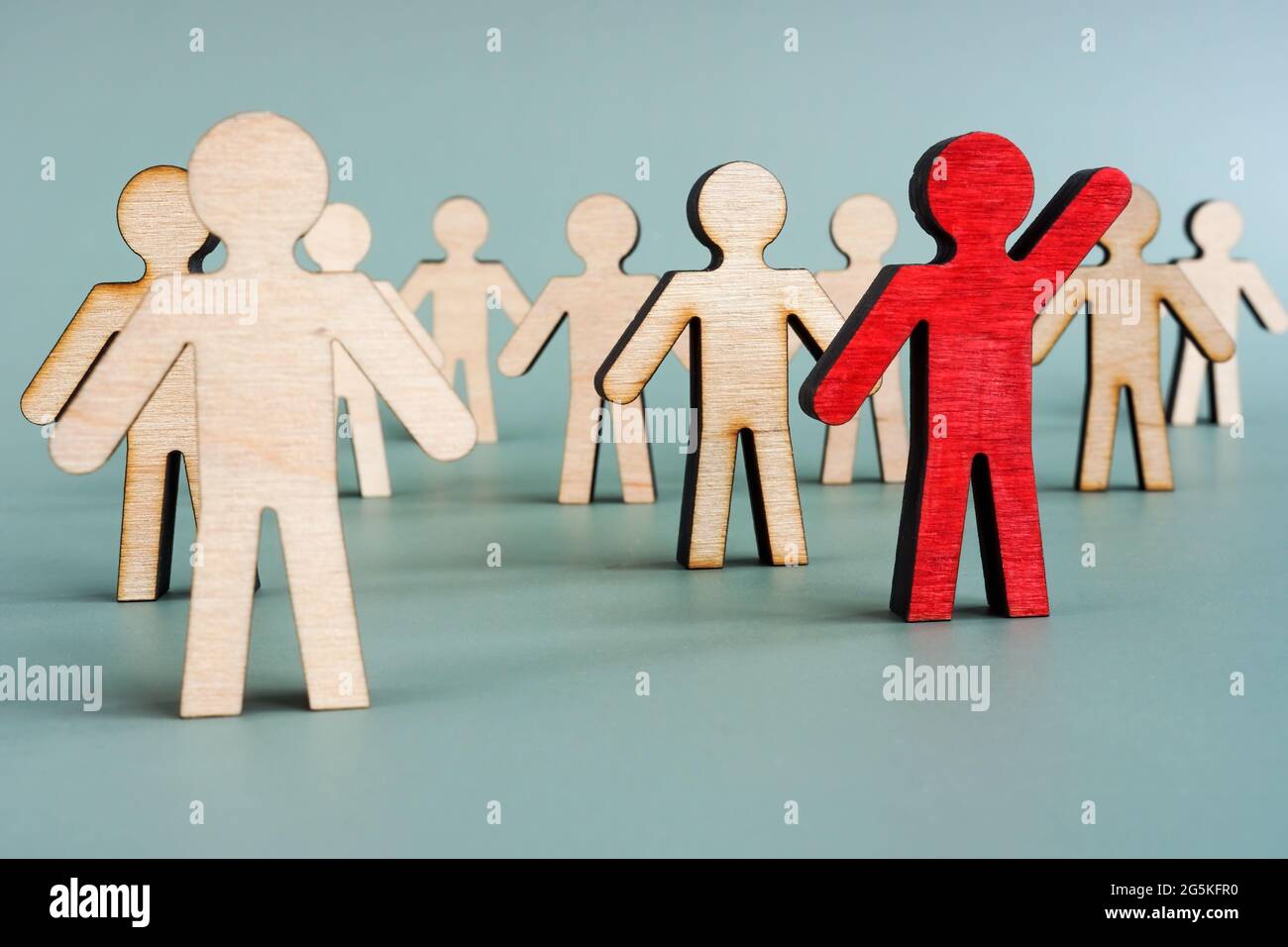 Figura di legno rosso nella folla. Concetto di sviluppo della leadership. Foto Stock