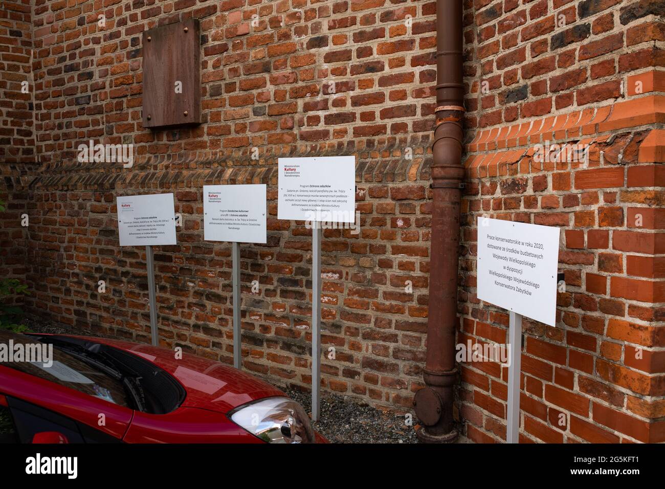 Gniezno, Polonia - informazioni rumore, messaggi in eccesso sui cartelli di fronte ad un monumento architettonico, la chiesa parrocchiale della Santa Trinità. Foto Stock
