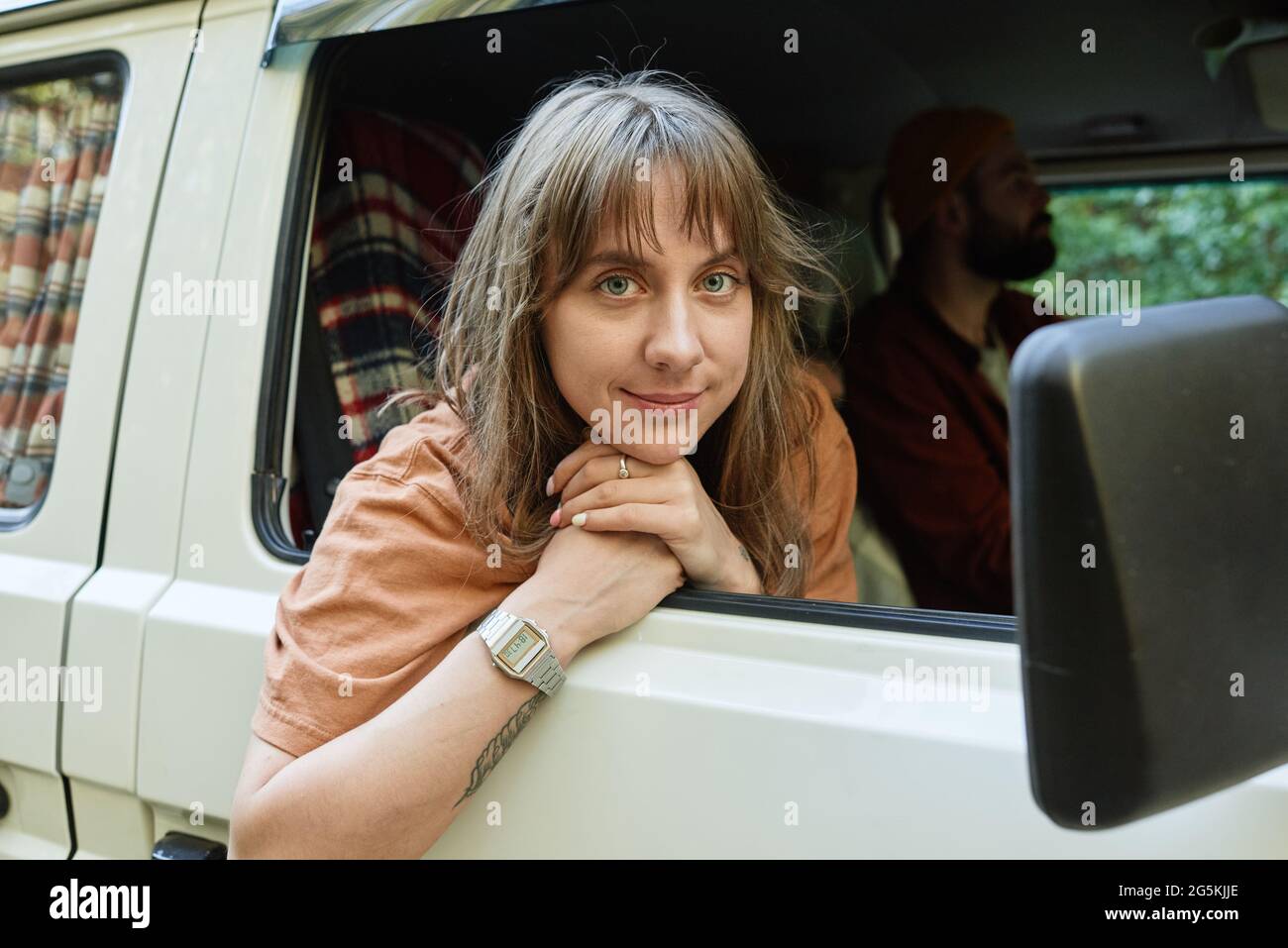 Ritratto di giovane donna che guarda la macchina fotografica mentre viaggia in autobus con i suoi amici Foto Stock