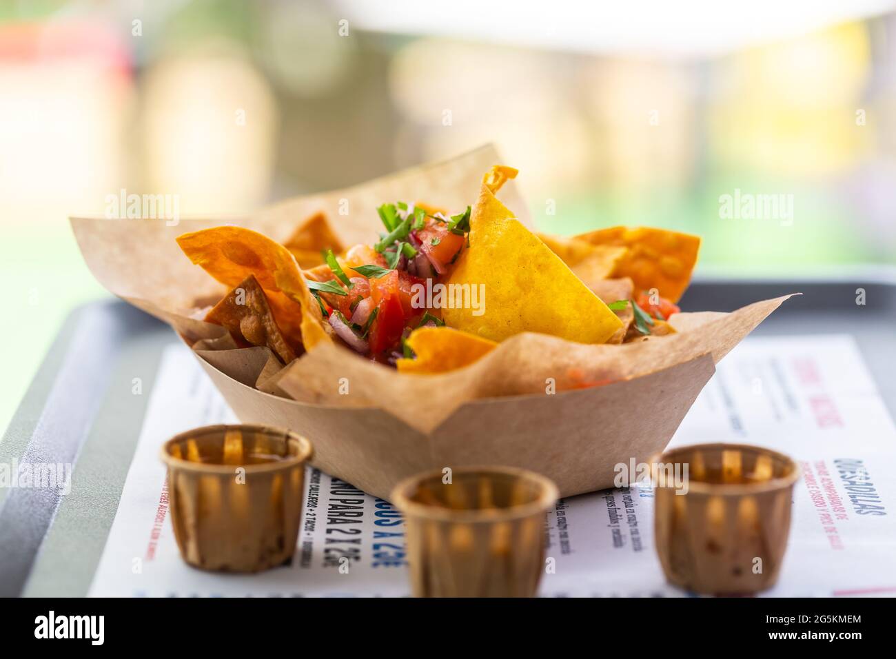 Salsa nachos in un caffè di strada su un piatto di carta con salse. Piatti messicani tradizionali Foto Stock