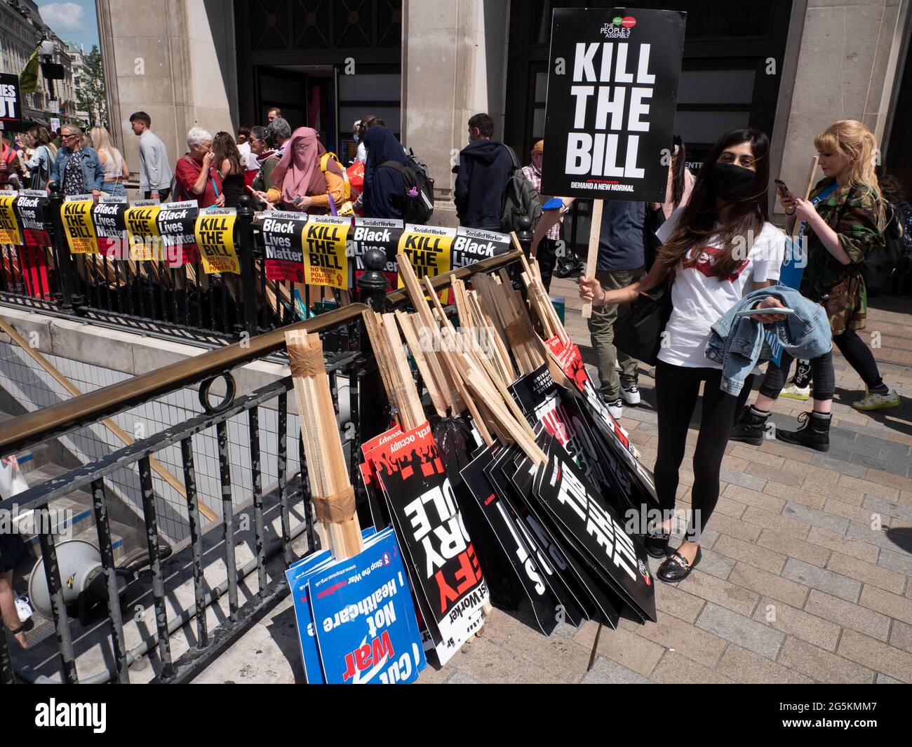 Proteste di Londra, attivisti protestano nel centro di Londra alla manifestazione nazionale dell'Assemblea popolare, giovane donna che tiene la targhetta Kill the Bill davanti alla fila di vari cartelli ad Oxford Circus Foto Stock
