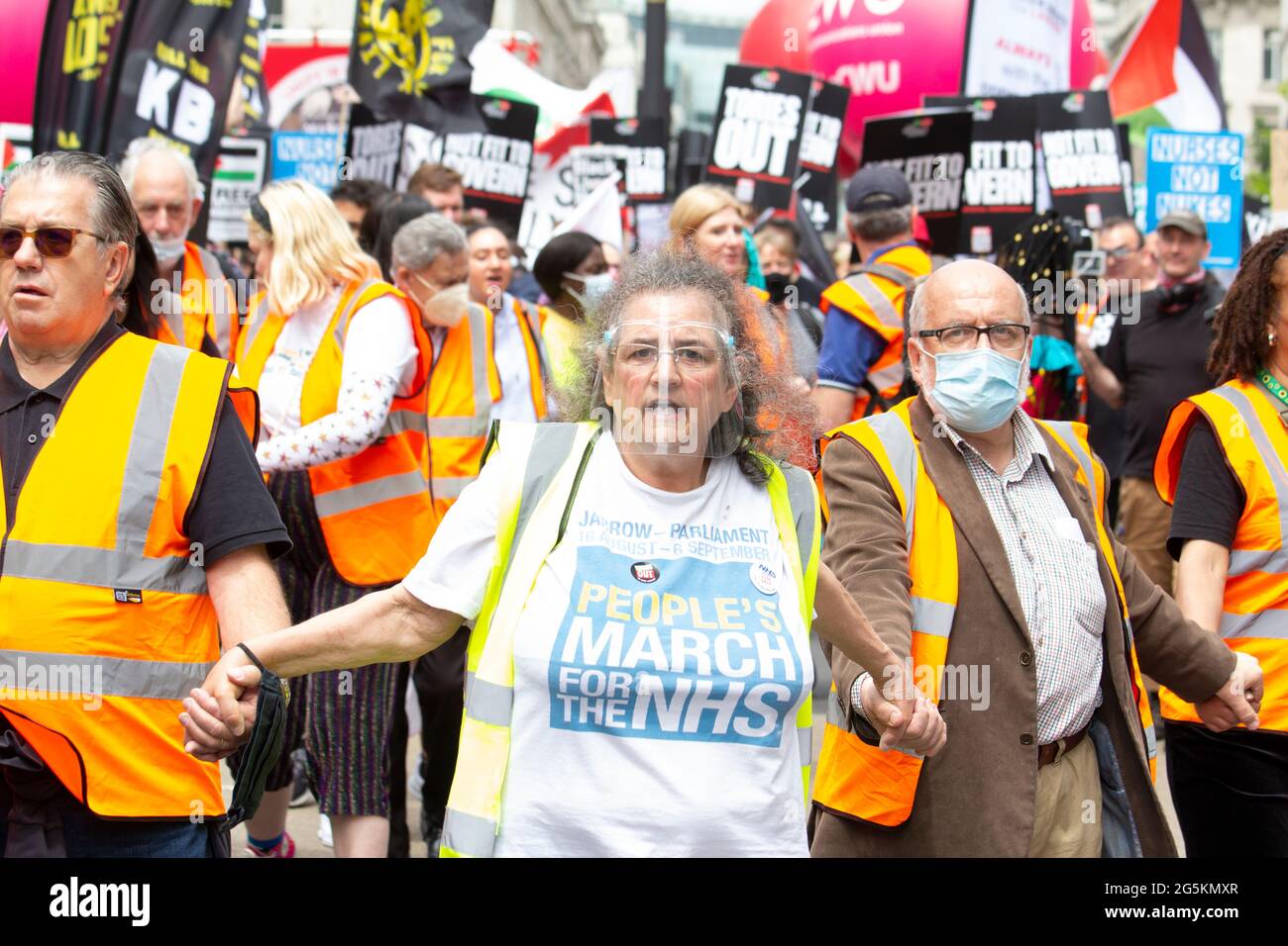 Le donne anziane che indossano i popoli marciano per l'emblema dell'NHS, e la maschera di scudo Covid alle proteste di Londra, gli attivisti del servizio sanitario nazionale Pro protestano nel centro di Londra alla dimostrazione nazionale dell'Assemblea popolare Foto Stock