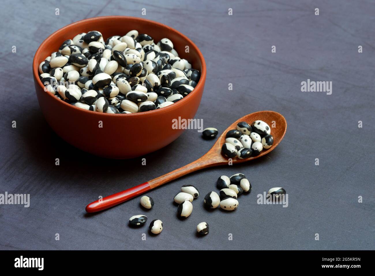 Fagioli secchi in ciotola con cucchiaio, fagioli Yin Yang Foto Stock