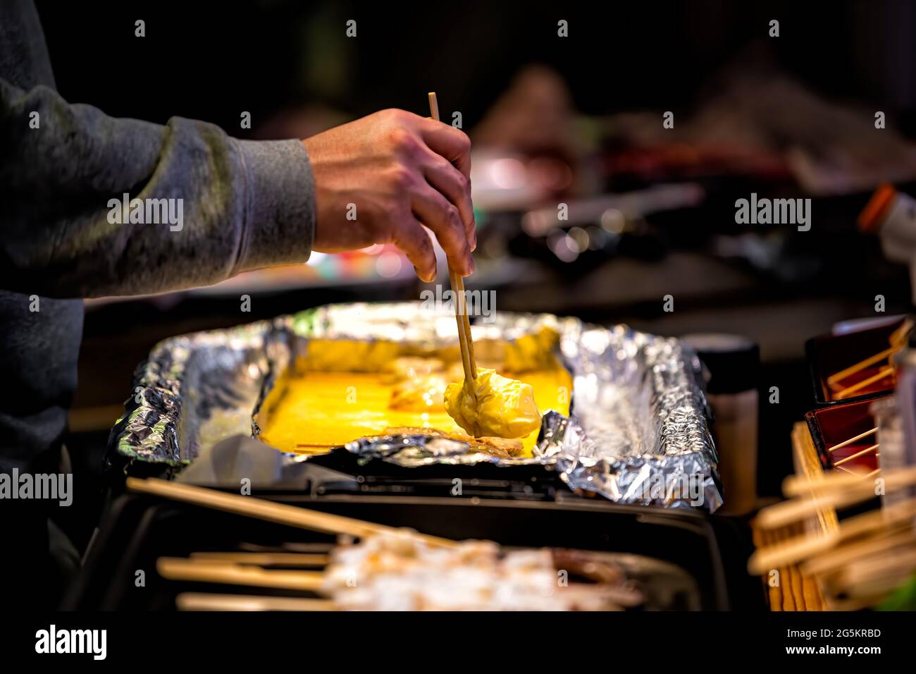 Primo piano di tamagoyaki uova giapponesi arrotolate omelette in esposizione al dettaglio a Kyoto, Giappone Nishiki strada mercato con persona servire porzione di omelette Foto Stock