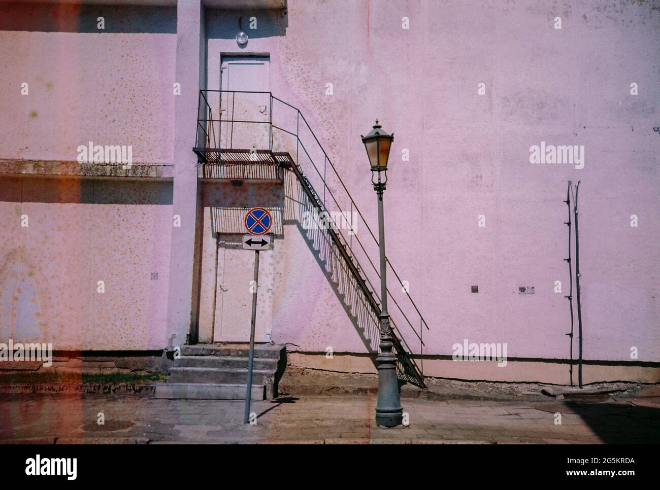 Foto vintage sfuocata e sgranata. Pellicola della fotocamera danneggiata. Immagine mistica, psichedelica, nostalgica. Muro, scale, lanterna di strada. Foto Stock