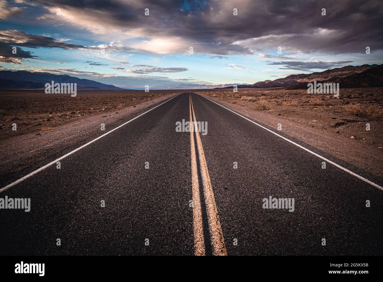 Solitario desolato strada si estende fino all'orizzonte, Death Valley National Park Foto Stock