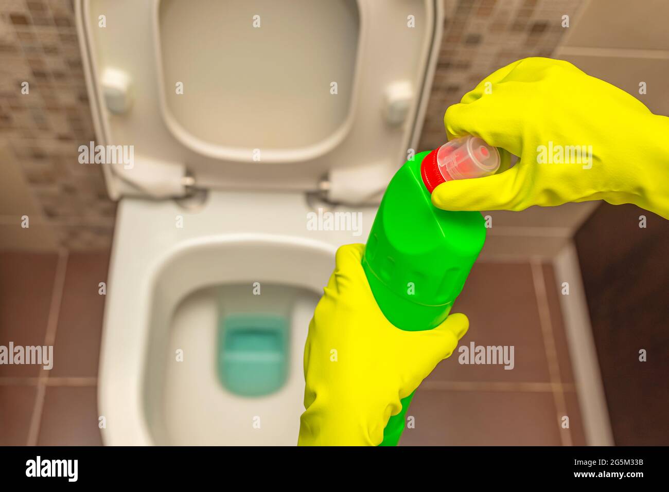Detergenti per toilette. Flacone di liquido. Vista dall'alto della toilette. Aprire manualmente il flacone del detergente per wc. Foto Stock