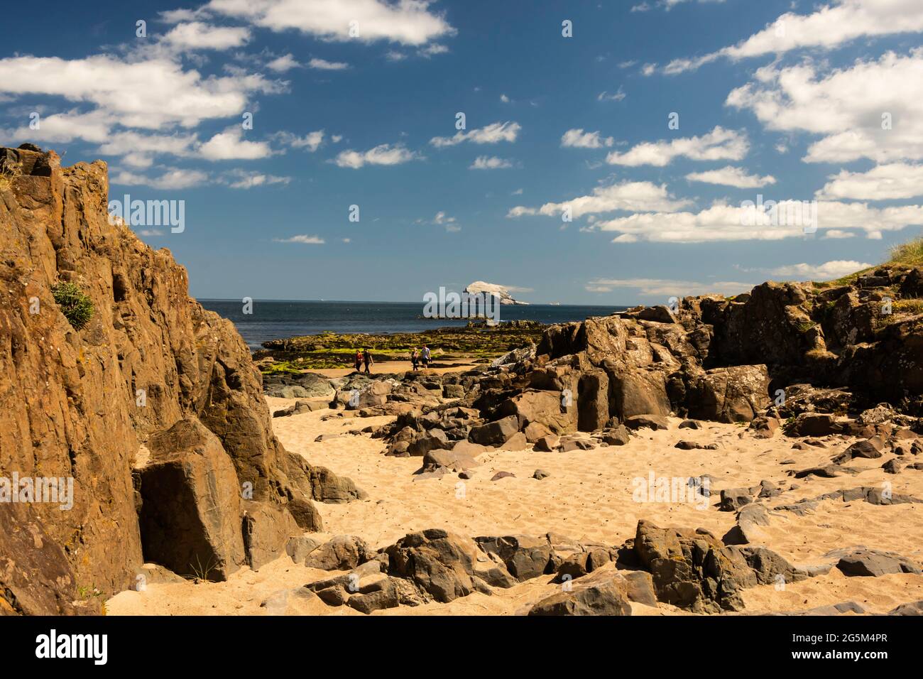 Turisti sconosciuti sulla spiaggia di North Berwick a East Lothian, Scozia, in una giornata estiva soleggiata con il Bass Rock sullo sfondo. Foto Stock