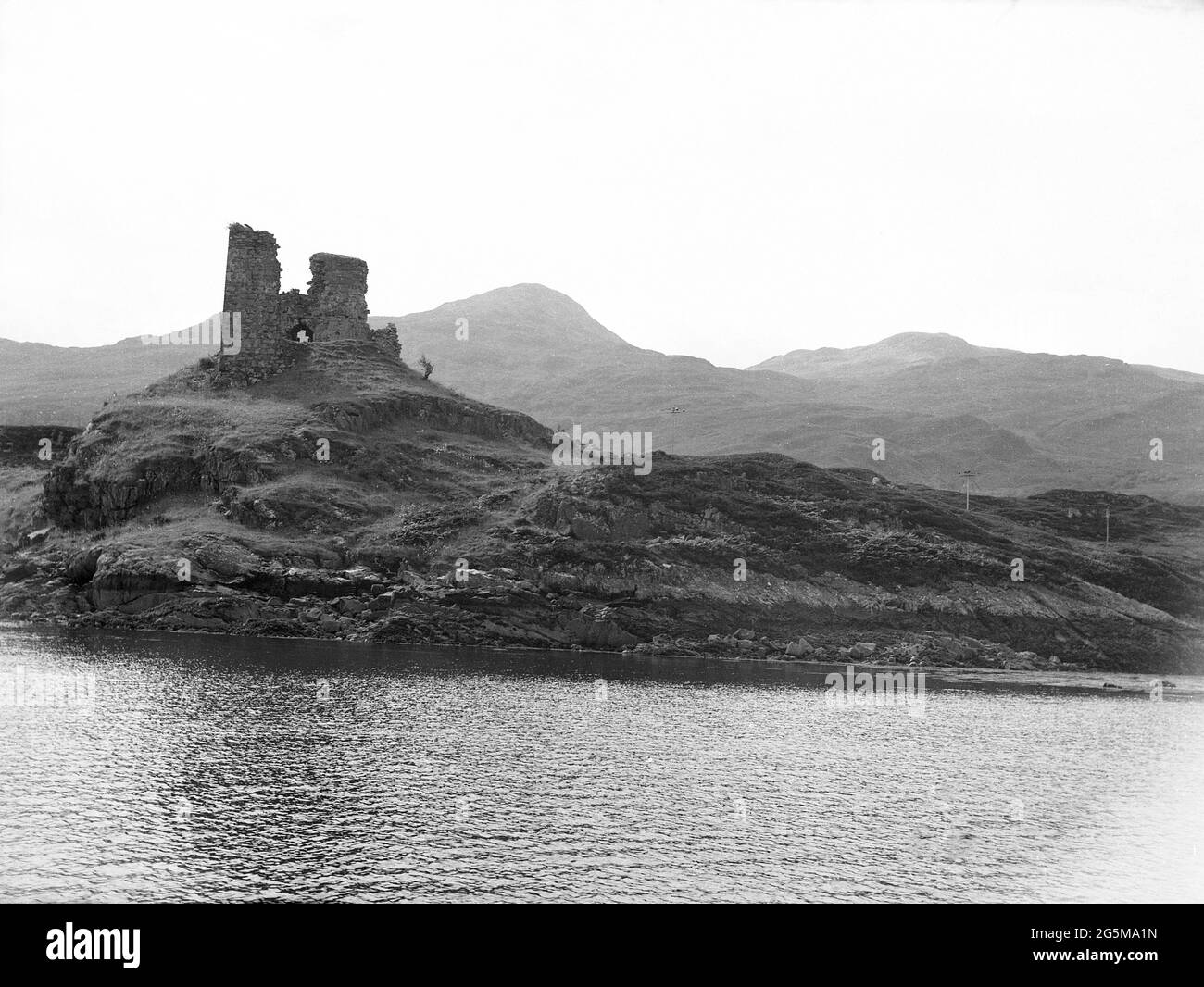1956, storica, Highlands scozzesi, rovine di pietra su un pezzo di terra rocciosa e di basso livello accanto ad un lago. Foto Stock