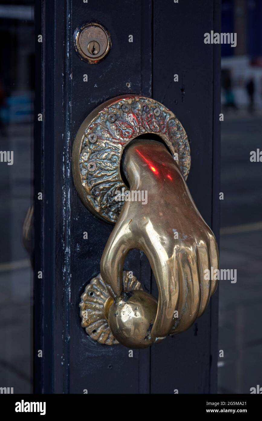 Maniglia in ottone a forma di mano che apre una porta, Edimburgo, Scozia, Regno Unito. Foto Stock