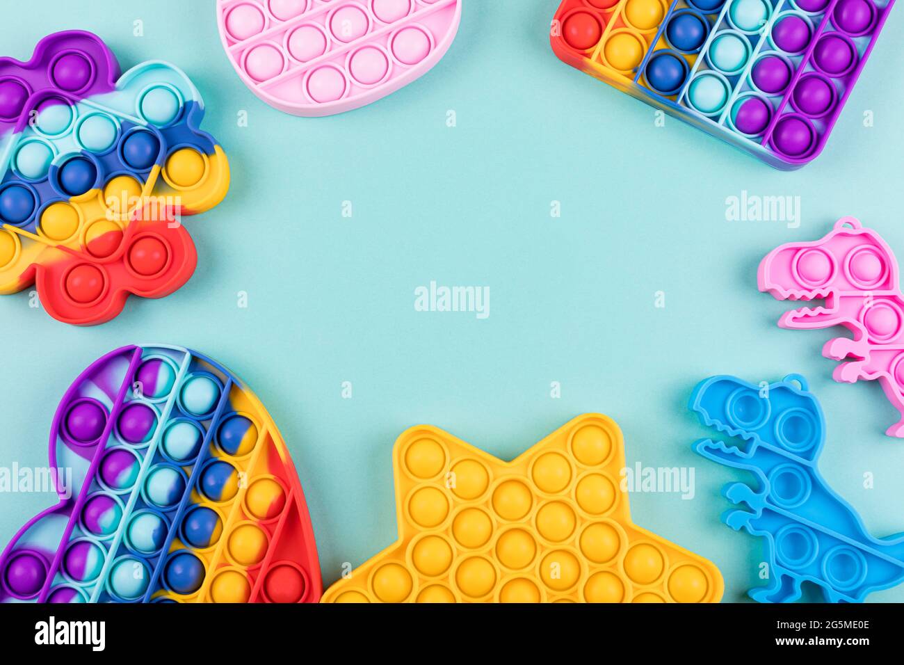 Set di popolari giocattoli di fidget colorati lo schioccano su sfondo blu. Nuovi giocattoli sensoriali anti-stress per bambini e adulti. Giocattoli a bolla di spinta alla moda. Copia spin Foto Stock