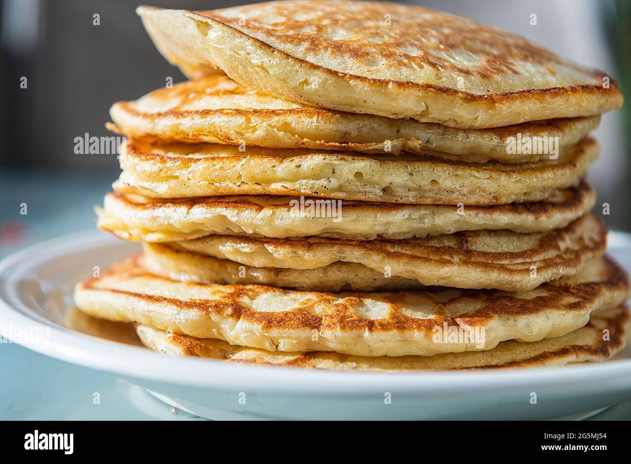 Macro Closeup vista laterale di una pila di pancake al latticello sul piatto come tradizionale dessert per il brunch della colazione Foto Stock