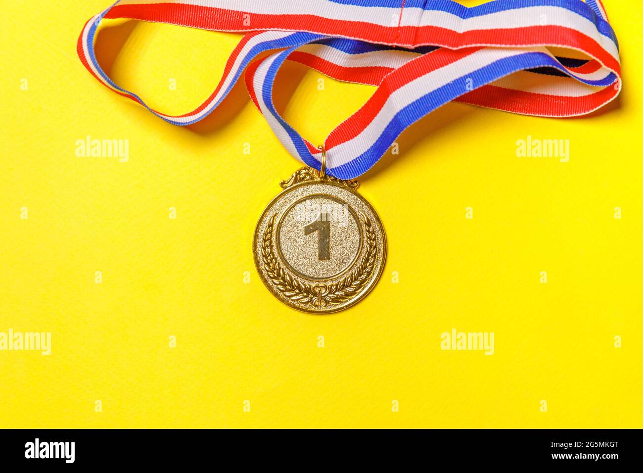 Semplicemente piatto Lay design vincitore o campione medaglia d'oro trofeo isolato su sfondo giallo colorato. Vittoria primo posto di gara. Vincendo o. Foto Stock