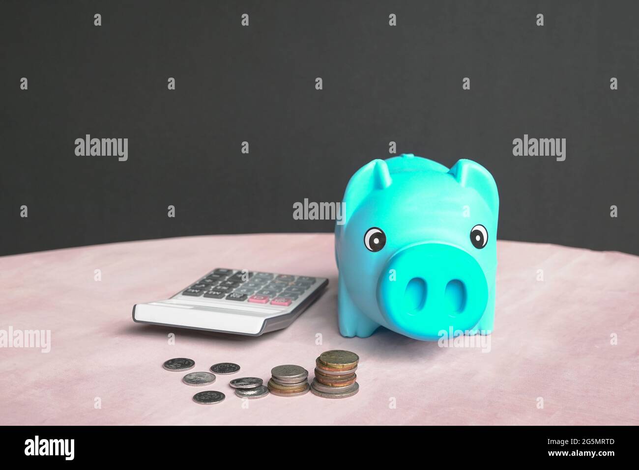 Banca di piggy, calcolatore e soldi sul tavolo. Spazio di copia. Foto Stock